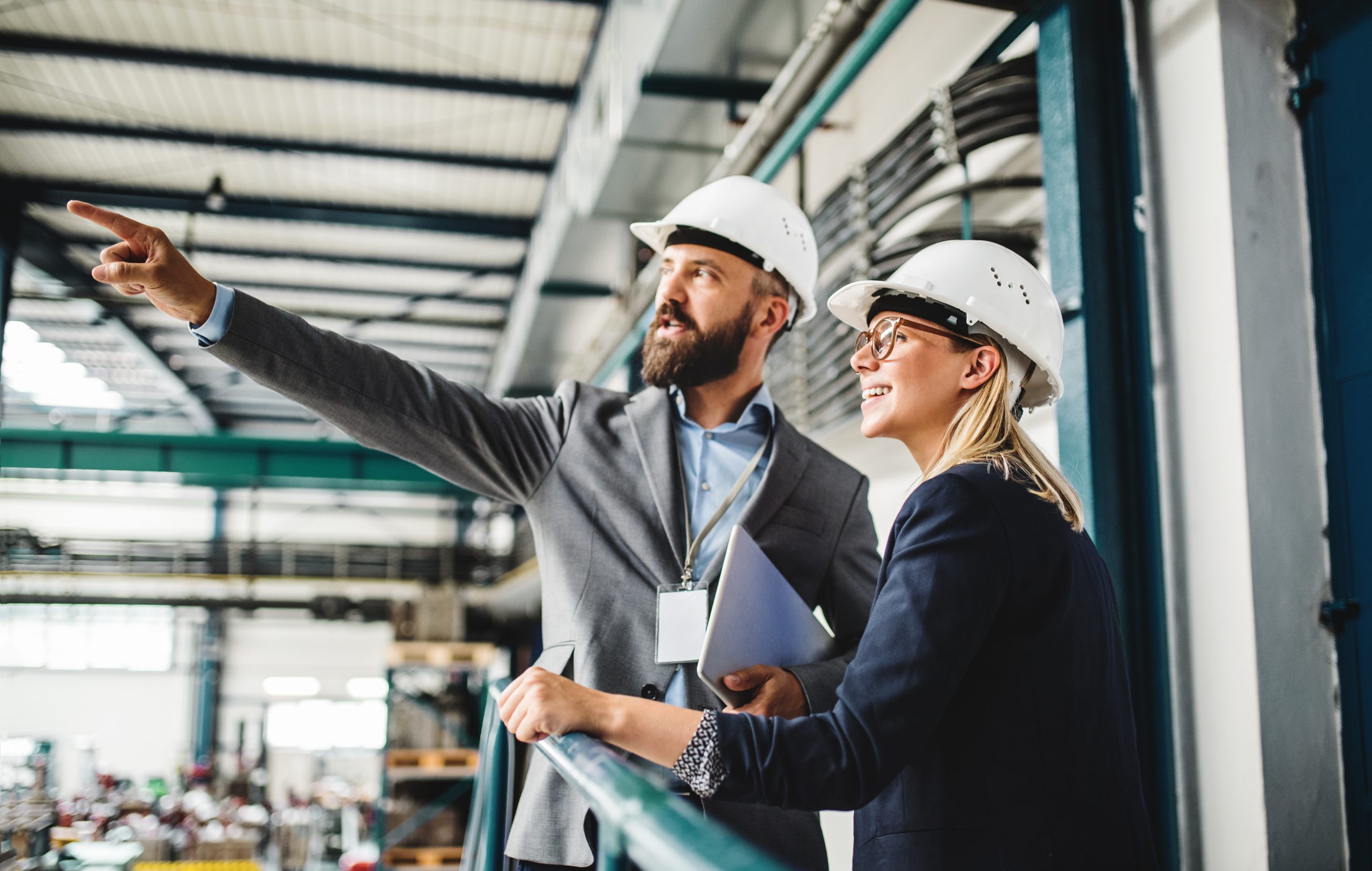 A portrait of an industrial man and woman engineer with tablet in a factory, working